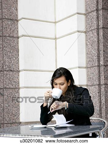 Stock Image - Businesswoman having coffee. Fotosearch