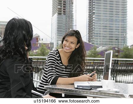 Stock Photograph - Businesswomen meeting at cafe. Fotosearch
