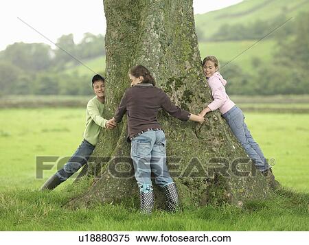 Stock Photography - Children Hugging Tree. Fotosearch