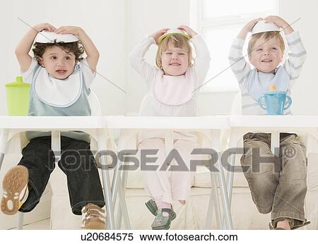 Stock Photography - Children with food bowls on their head.. Fotosearch