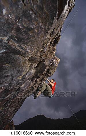 Climber bouldering on a rock face. View Large Photo Image Stock Image - Climber bouldering on a rock face.. Fotosearch