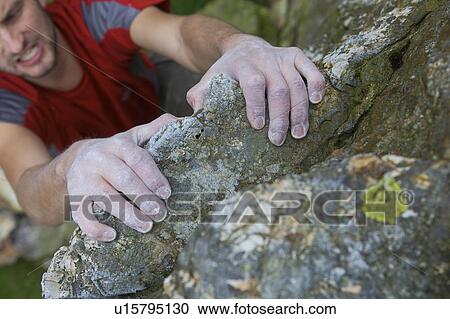 Stock Image - Climbers hands on a rock face.. Fotosearch