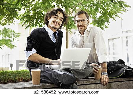 Stock Image - Colleagues having coffee, smiling. Fotosearch