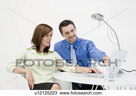 Stock Image - Colleagues looking at a laptop. Fotosearch