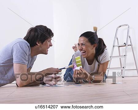 Stock Photo - Couple choosing paint colours.. Fotosearch