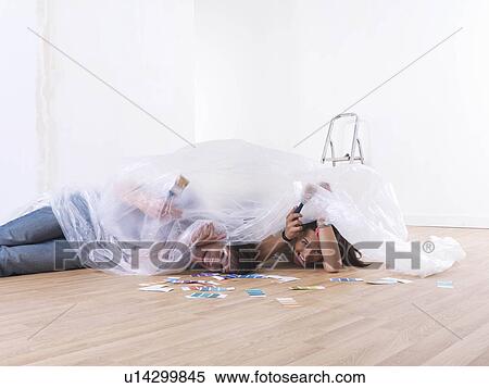 Stock Photography - Couple choosing paint colours.. Fotosearch