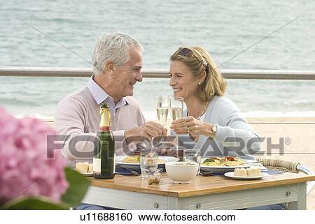 Stock Image - Couple dining at seaside restaurant. Fotosearch