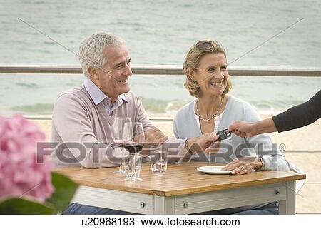 Couple dining at seaside restaurant View Large Photo Image Stock Image - Couple dining at seaside restaurant. Fotosearch