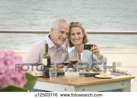 Stock Photograph - Couple dining at seaside restaurant. Fotosearch