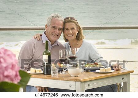 Stock Photograph - Couple dining at seaside restaurant. Fotosearch