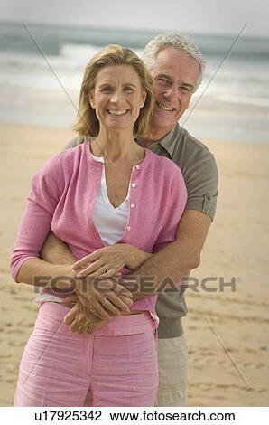 Couple embracing on a beach View Large Photo Image Stock Image - Couple embracing on a beach. Fotosearch