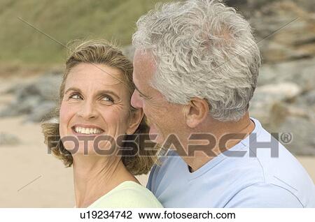 Stock Image - Couple embracing on a beach. Fotosearch