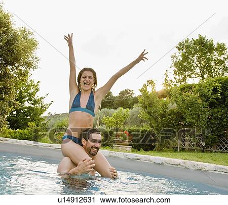 Stock Image - Couple enjoying sun in pool. Fotosearch