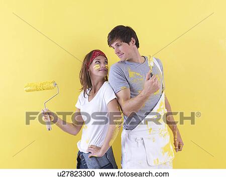 Stock Image - Couple posing in front of wall.. Fotosearch