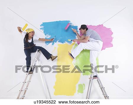 Stock Image - Couple posing on ladders.. Fotosearch
