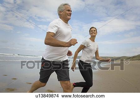 Picture - Couple running on a beach. Fotosearch