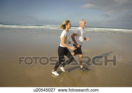 Stock Photo - Couple running on a beach. Fotosearch