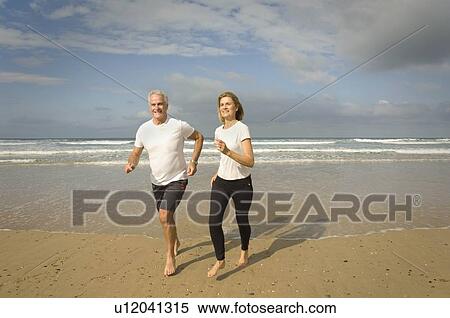 Stock Photography - Couple running on a beach. Fotosearch