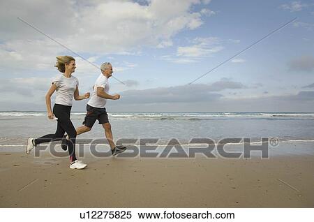 Stock Photography - Couple running on a beach. Fotosearch