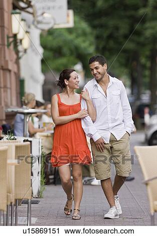 Couple walking down street View Large Photo Image Stock Image - Couple walking down street. Fotosearch
