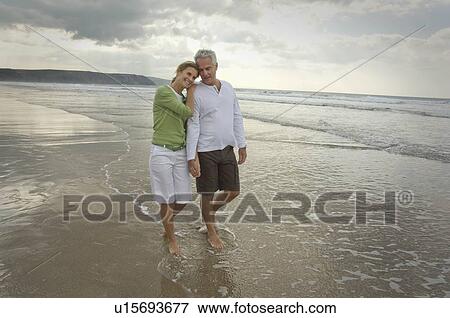 Stock Photo - Couple walking on a beach. Fotosearch