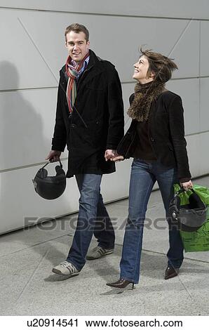 Couple walking with motorcycle helmets View Large Photo Image Stock Image - Couple walking with motorcycle helmets. Fotosearch