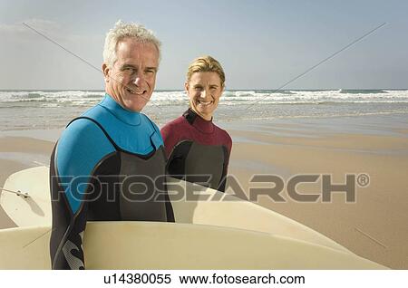 Couple with surfboards on a beach View Large Photo Image Stock Photography - Couple with surfboards on a beach. Fotosearch
