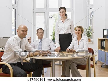 Stock Image - Coworkers talking over a meeting. Fotosearch