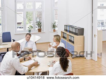 Stock Photo - Coworkers talking over a meeting. Fotosearch