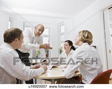 Coworkers talking over a meeting View Large Photo Image Stock Photo - Coworkers talking over a meeting. Fotosearch