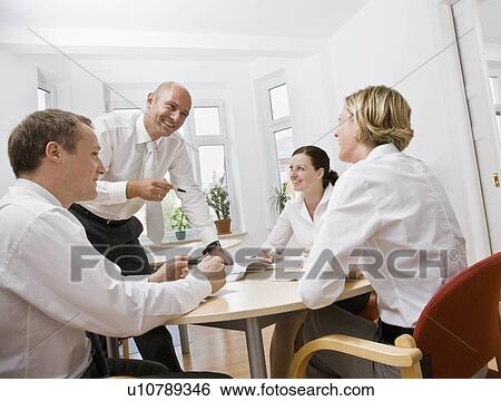 Stock Photograph - Coworkers talking over a meeting. Fotosearch