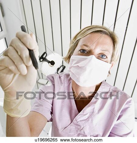 Stock Photography - Dental assistant using tools. Fotosearch
