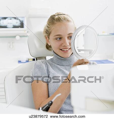 Dental patient looking at a mirror View Large Photo Image Stock Image - Dental patient looking at a mirror. Fotosearch