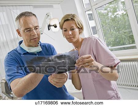 Stock Photograph - Dentist and assistant looking at x-rays. Fotosearch