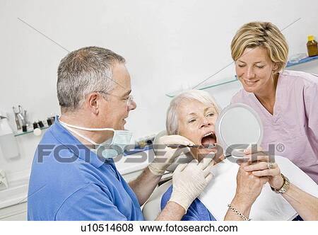 Stock Photo - Dentist and assistant working on patient. Fotosearch