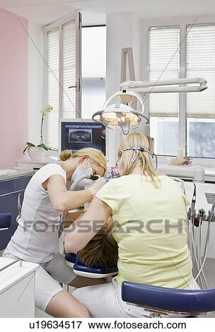 Stock Photo - Dentist with patient and assistant. Fotosearch