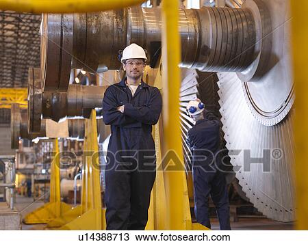 Stock Image - Engineer Next To Turbines. Fotosearch