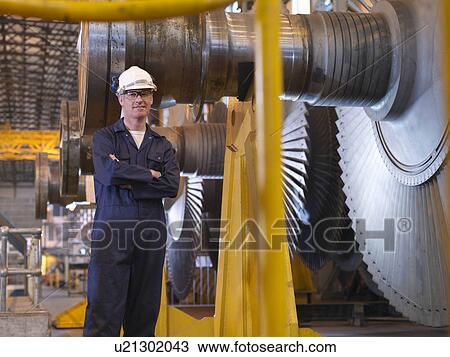Stock Image - Engineer Next To Turbines. Fotosearch