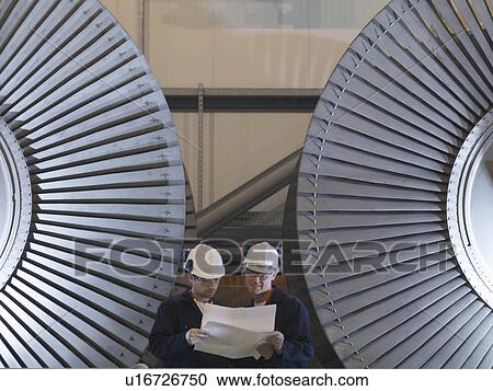 Stock Image - Engineers In Front Of Turbines. Fotosearch