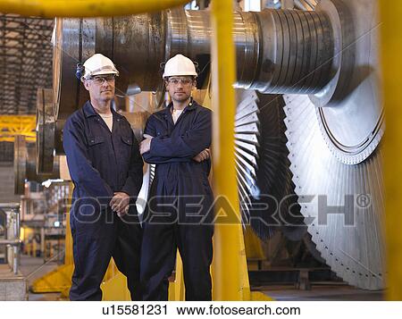 Stock Image - Engineers Next To Turbines. Fotosearch