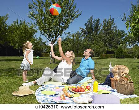 Stock Image - Family having a picnic in the garden. Fotosearch