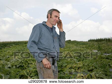 Stock Photo - farm worker on mobile. Fotosearch