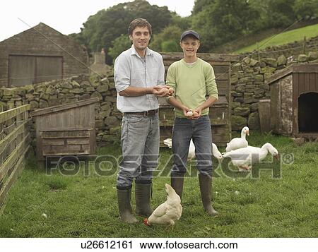 Stock Image - Farmer And Boy Holding Eggs. Fotosearch
