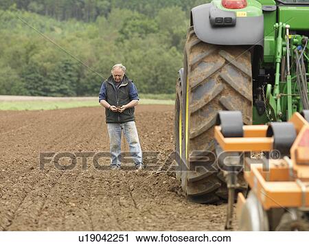 Farmer Examining Soil In Field View Large Photo Image Stock Image - Farmer Examining Soil In Field. Fotosearch