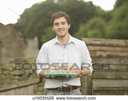 Stock Photo - Farmer Holding A Tray Of Eggs. Fotosearch