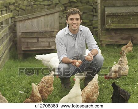 Stock Photo - Farmer Holding Eggs With Hens And Geese. Fotosearch