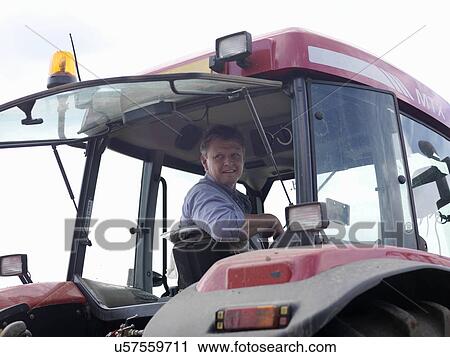 Stock Image - Farmer In Tractor. Fotosearch