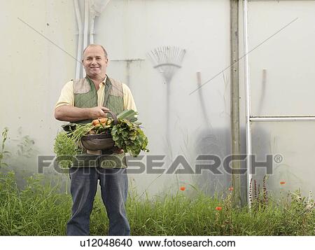 Stock Image - Farmer With Basket Of Vegetables. Fotosearch