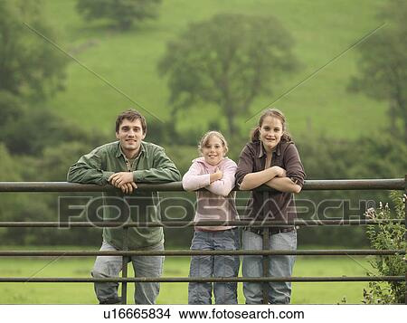 Picture - Farmer With Girls On Gate. Fotosearch