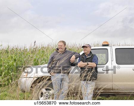 Stock Image - Farmers In Field With Car. Fotosearch